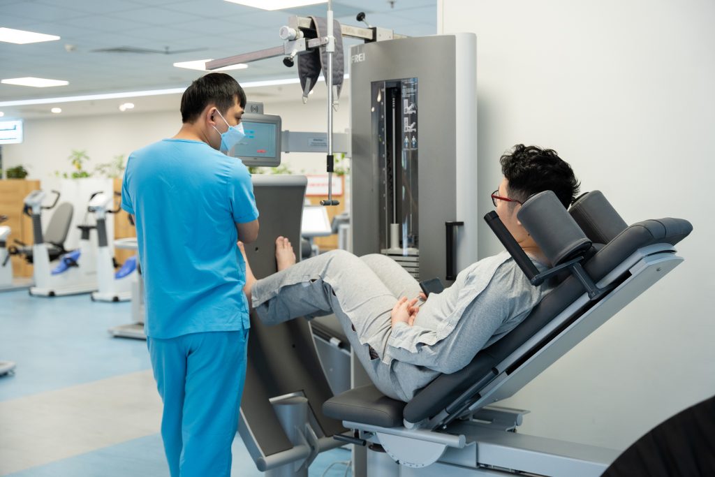 Người bệnh tập làm khỏe cơ tứ đầu đùi với máy tại Myrehab Matsuoka
